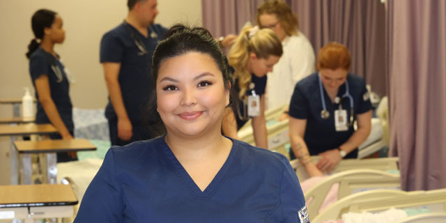 Psychiatric Nursing student posing in front of other students working in background