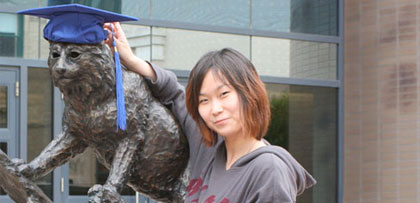Student posing next to Bobcat statue