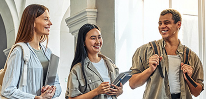 Three students smiling during conversation
