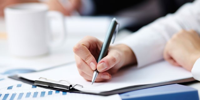 Hand writing on clipboard.