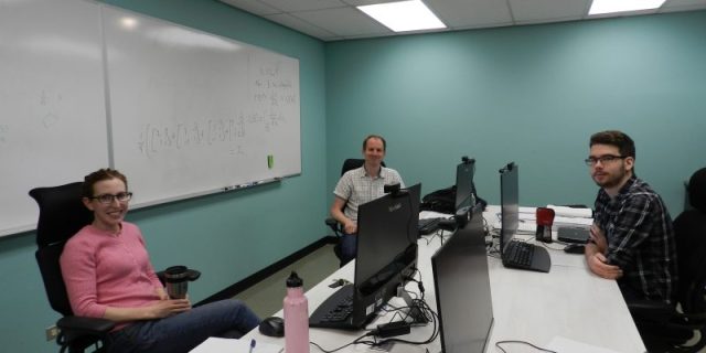 Three people sitting in Quantum Computing Lab